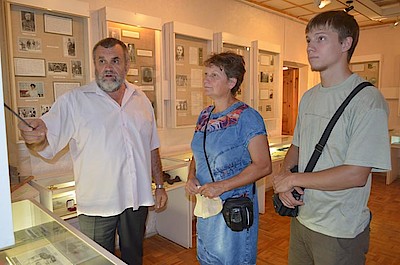 Новости Ливны -Сотрудник музея В. А. Бобков показывает экспозицию дочери и внуку А. Г. Шипунова (фото автора).